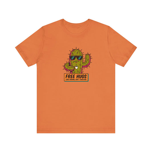 Orange t-shirt with cactus wearing sunglasses, holding a coffee mug, text "FREE HUGS (JUST KIDDING, DON'T TOUCH ME!)"