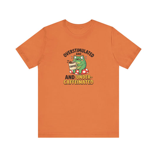 Orange t-shirt with graphic of an overstimulated, caffeinated frog holding coffee.