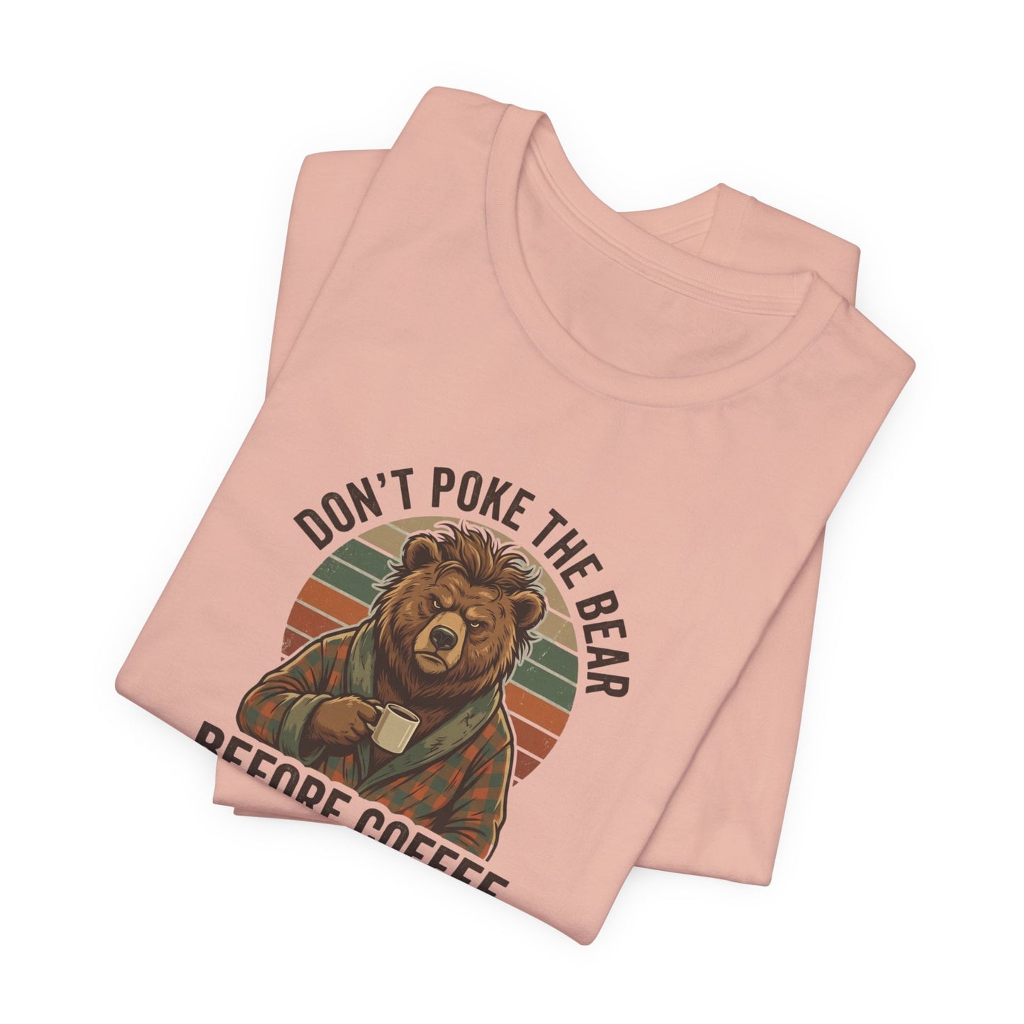 Pink t-shirt with graphic of a bear drinking coffee and text "DON'T POKE THE BEAR BEFORE COFFEE".