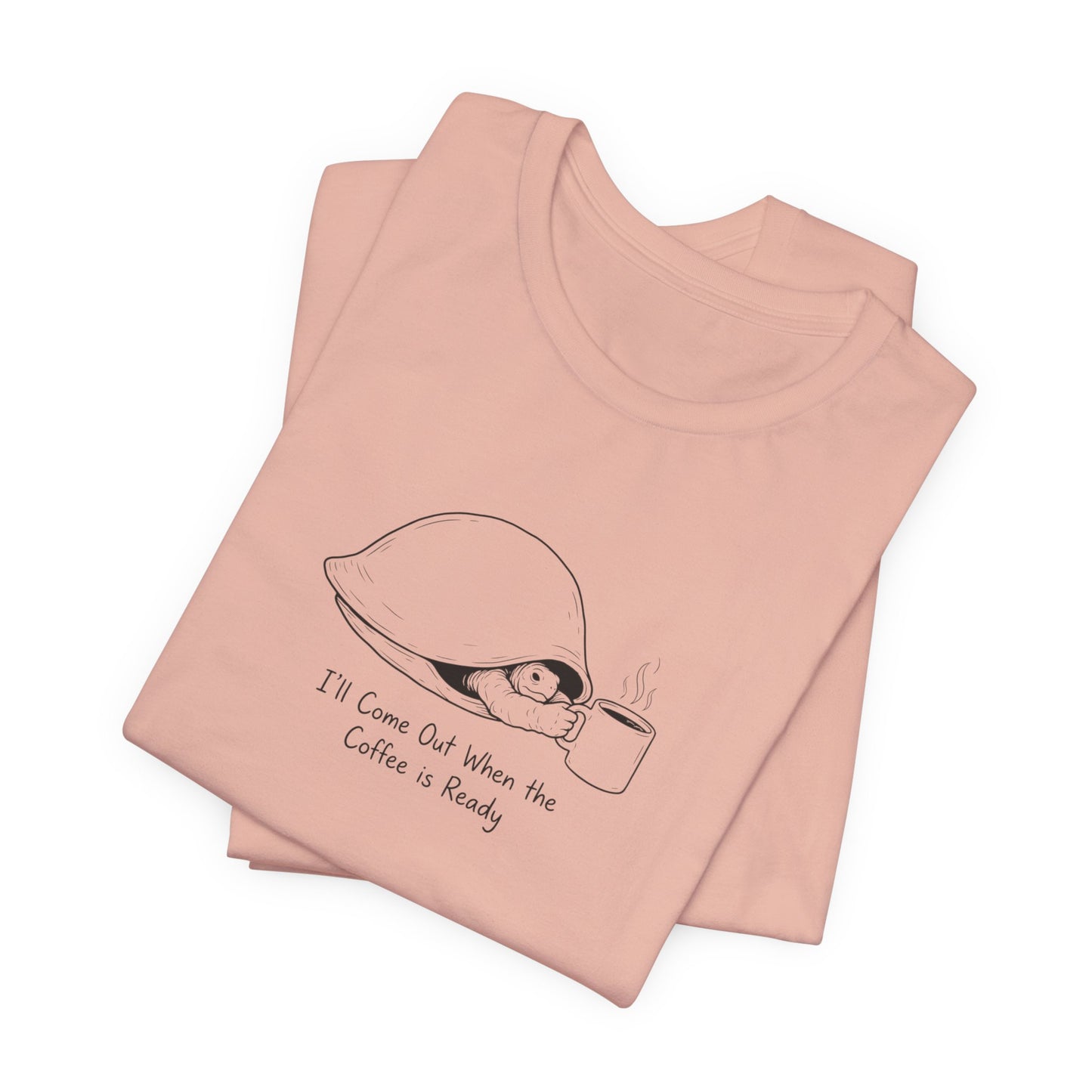 Pink t-shirt with a drawing of a turtle holding a coffee cup and steam.