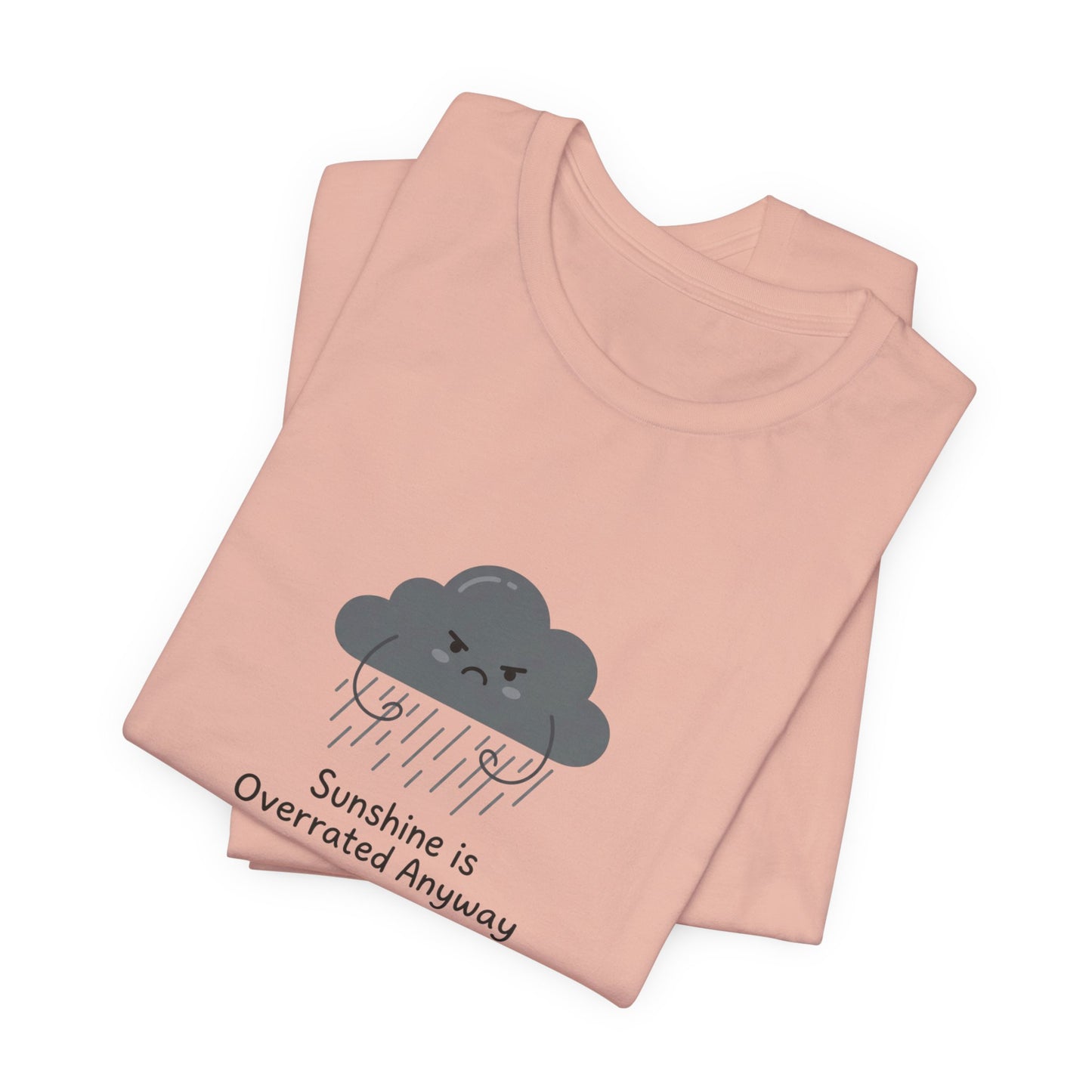 Pink t-shirt with folded graphic of a grumpy cloud and text "Sunshine is Overrated Anyway".