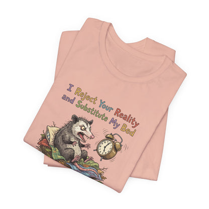 Opossum wearing a shirt with text "I Reject Your Reality and Substitute My Bed".