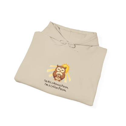 Cream hoodie with illustration of an owl holding a coffee cup, with text.
