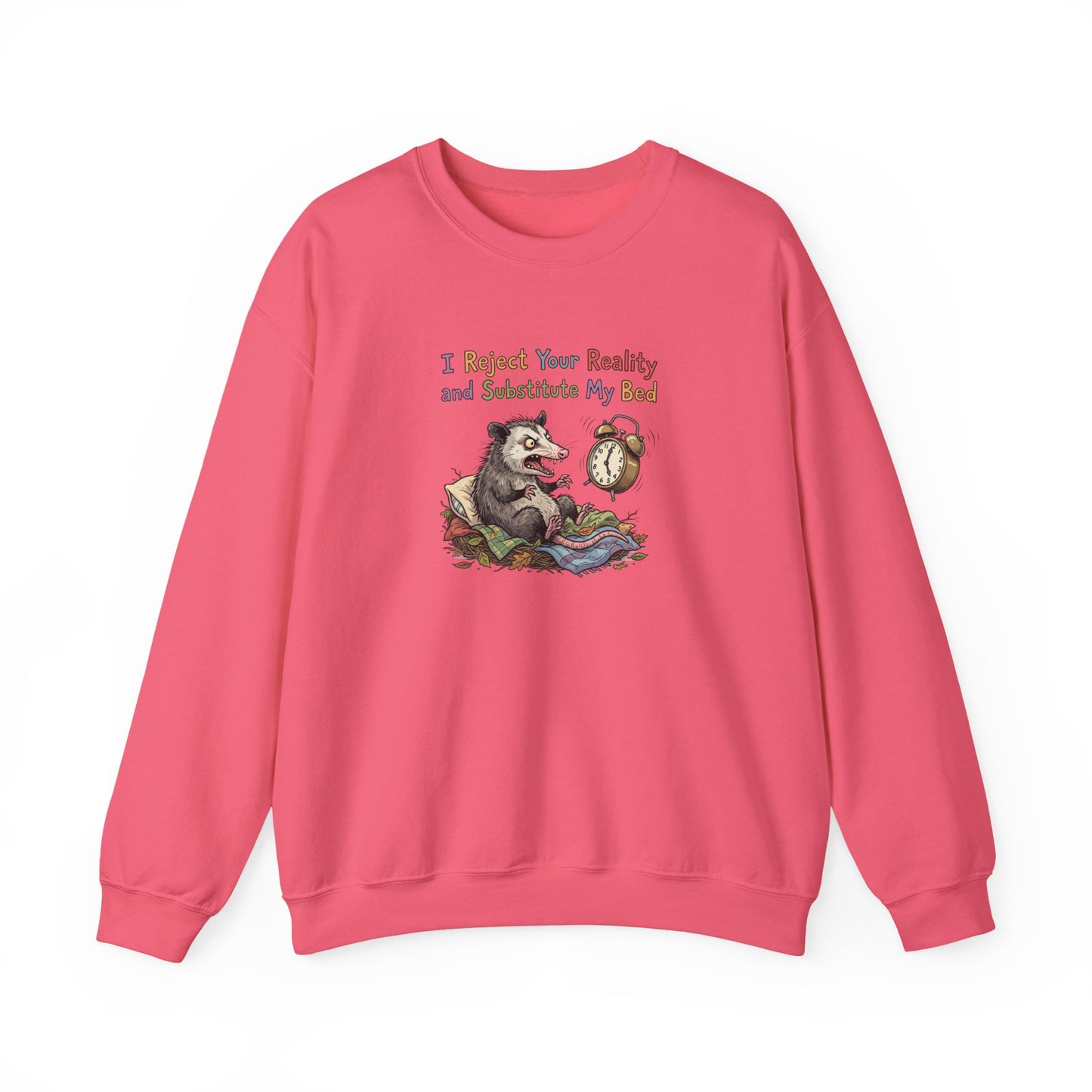 Pink sweatshirt with a cartoon opossum in bed and text "I Reject Your Reality and Substitute My Bed".
