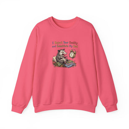 Pink sweatshirt with a cartoon opossum in bed and text "I Reject Your Reality and Substitute My Bed".