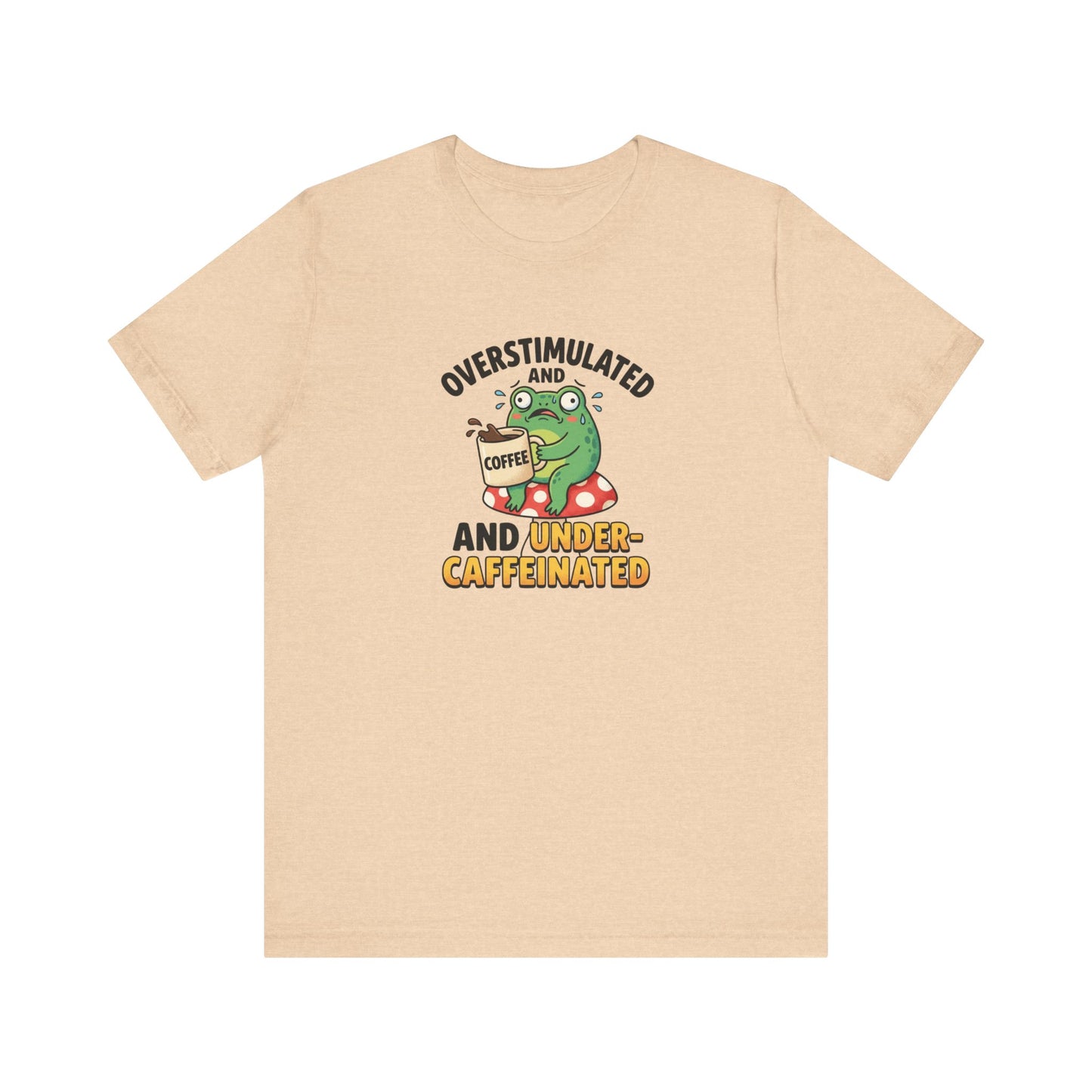 T-shirt graphic of a frog on a mushroom, holding coffee, with text "overstimulated and caffeinated".