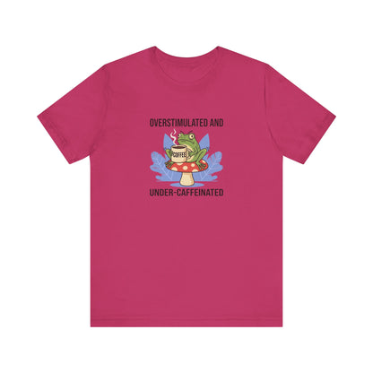 T-shirt with a frog on a mushroom holding a coffee cup, text reads "Overstimulated and Under-Caffeinated".