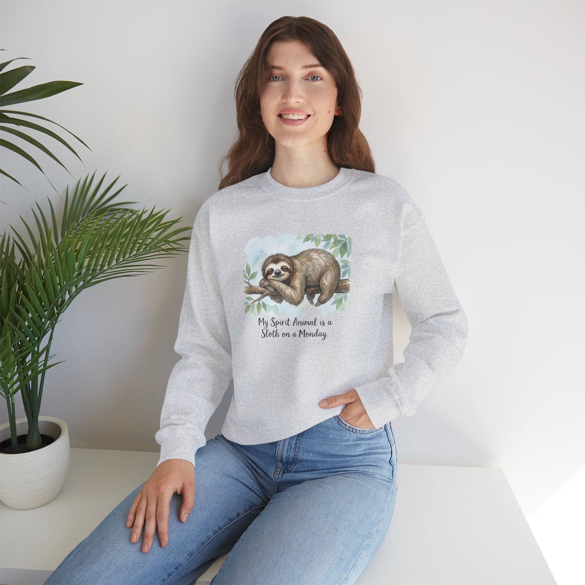 Woman wearing a grey sweatshirt with a sloth illustration and text.