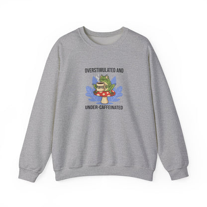 Gray sweatshirt with frog on mushroom drinking coffee, text "Overstimulated and Under-Caffeinated".