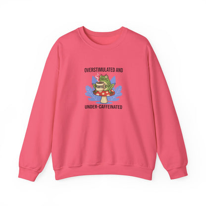 Pink crewneck sweatshirt with frog and "Overstimulated and Under-Caffeinated" text.