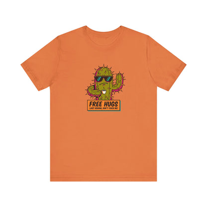 Orange t-shirt with cactus wearing sunglasses, holding a coffee mug, text "FREE HUGS (JUST KIDDING, DON'T TOUCH ME!)"
