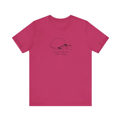 Pink t-shirt with a turtle wearing a shell, holding a coffee cup, with text.