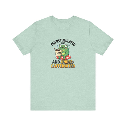 Green t-shirt with a cartoon frog holding a coffee cup, feeling overstimulated and caffeinated.