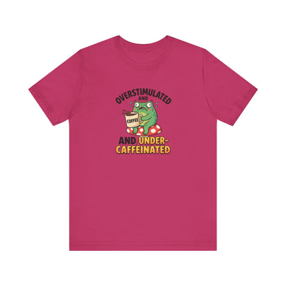 Frog with coffee cup on mushroom, text reads "Overstimulated and Under-Caffeinated".