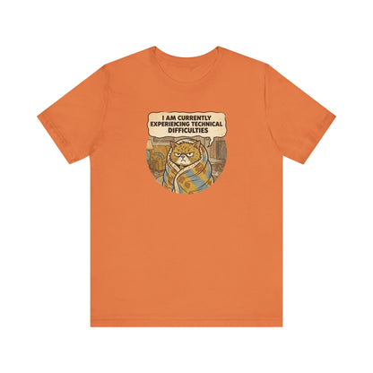 Orange t-shirt with a cartoon cat wrapped in a blanket saying "I am currently experiencing technical difficulties."