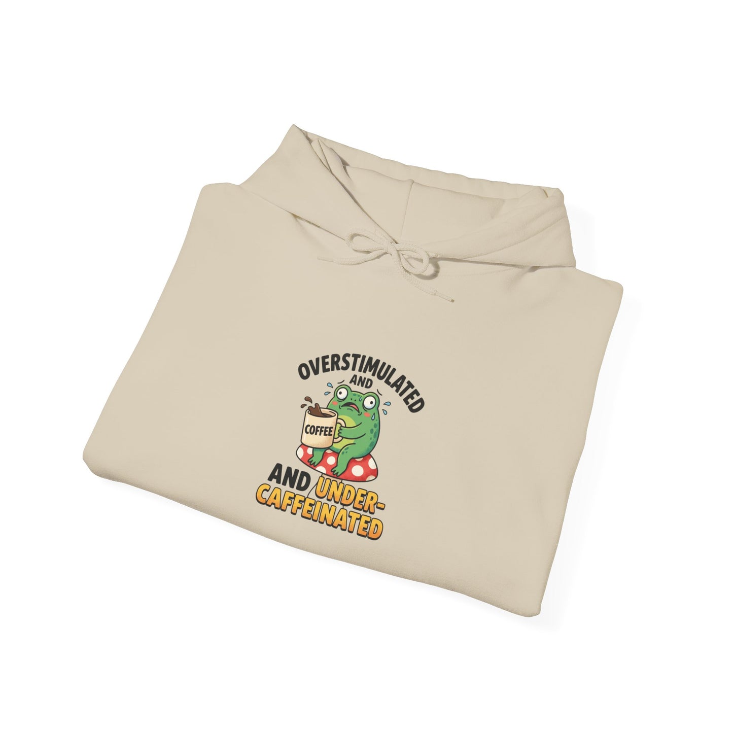 Beige hooded sweatshirt with frog on mushroom, "Overstimulated and Under-Caffeinated" text.
