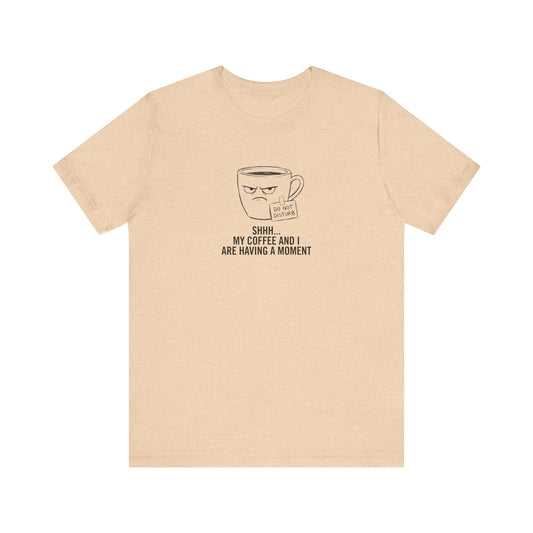 Light tan t-shirt with a grumpy coffee cup graphic and "DO NOT DISTURB SHHH... MY COFFEE AND I ARE HAVING A MOMENT" text.